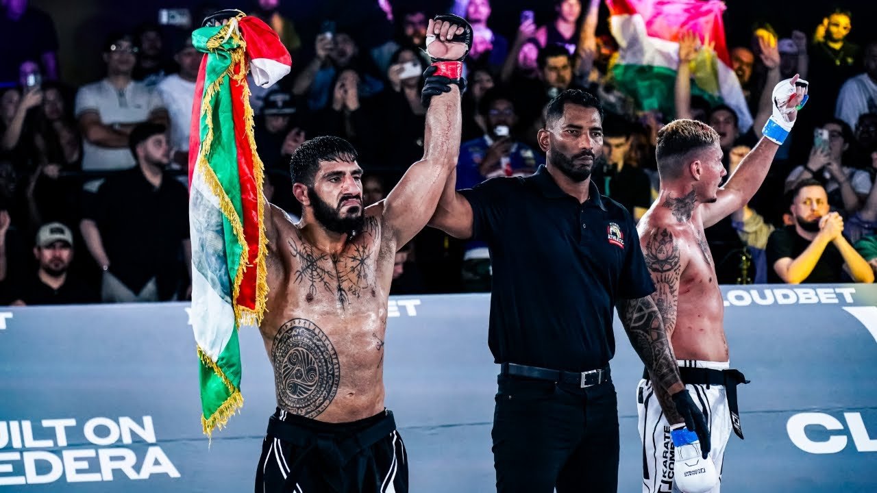 Namo Fazil getting his hand raised in victory holding the Kurdistan flag in the cage